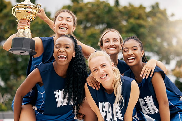 A sports team holds a trophy and smiles